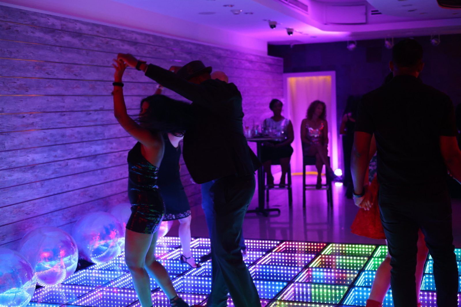 A dancer turning under purple event lights