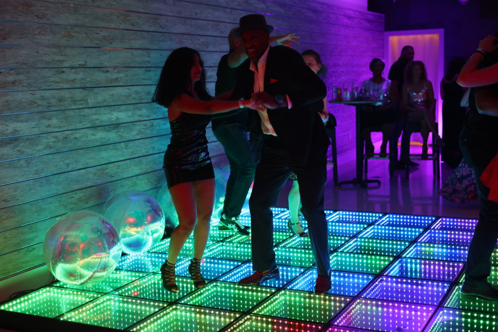 A close partner hold under colorful lights