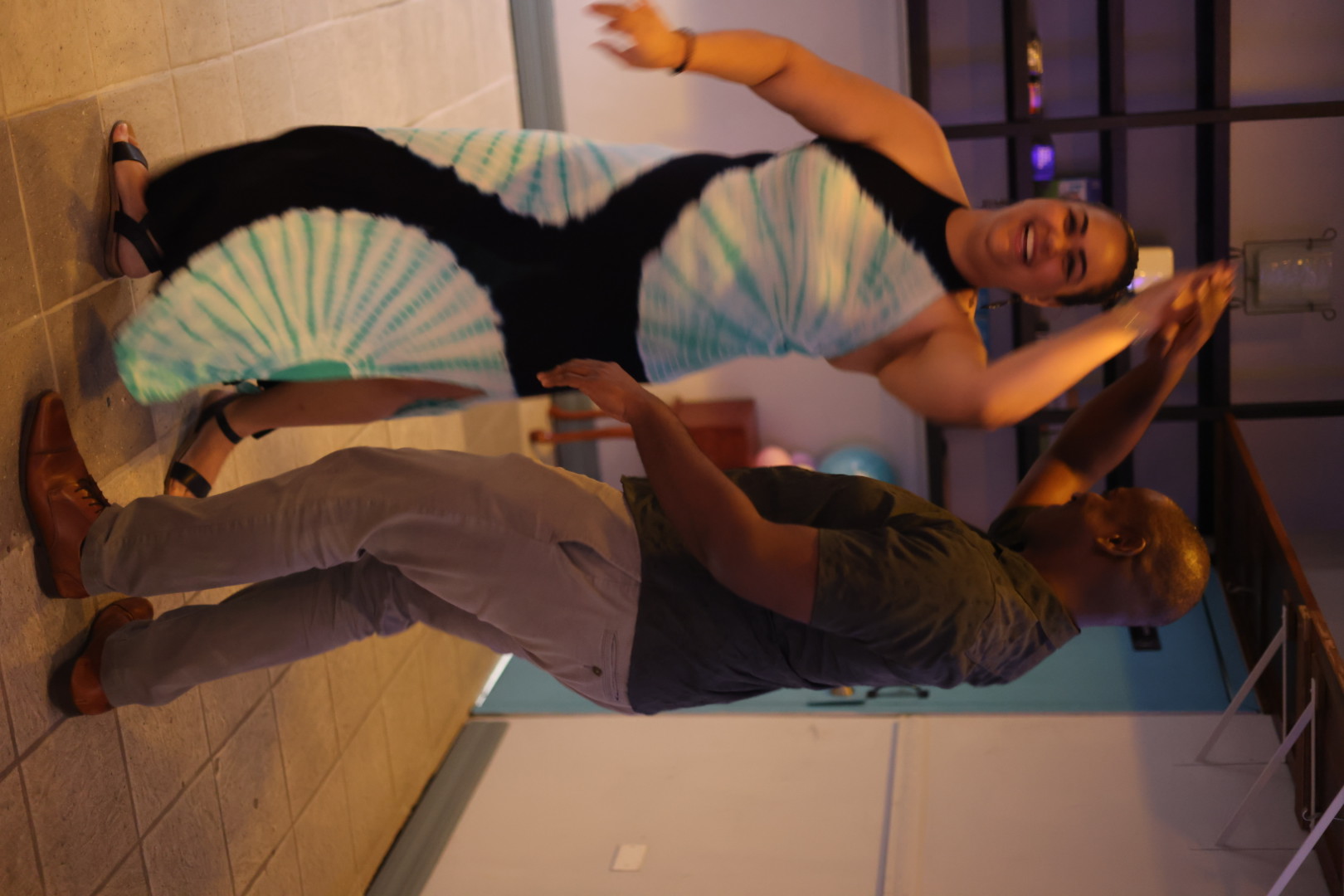 A smiling dancer turning beneath her partner’s arm