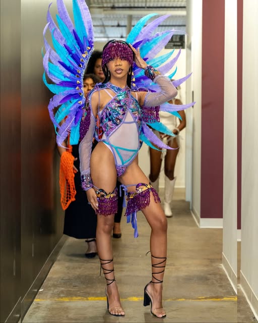 Jazz backstage wearing a purple and turquoise feathered costume