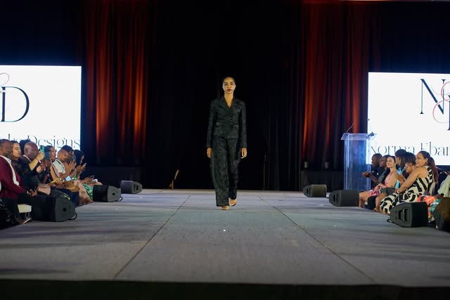 Jazz walking a runway in a dark tailored outfit