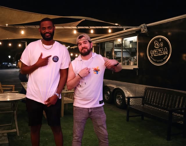 Two men wearing Latin Fusion shirts at an outdoor social