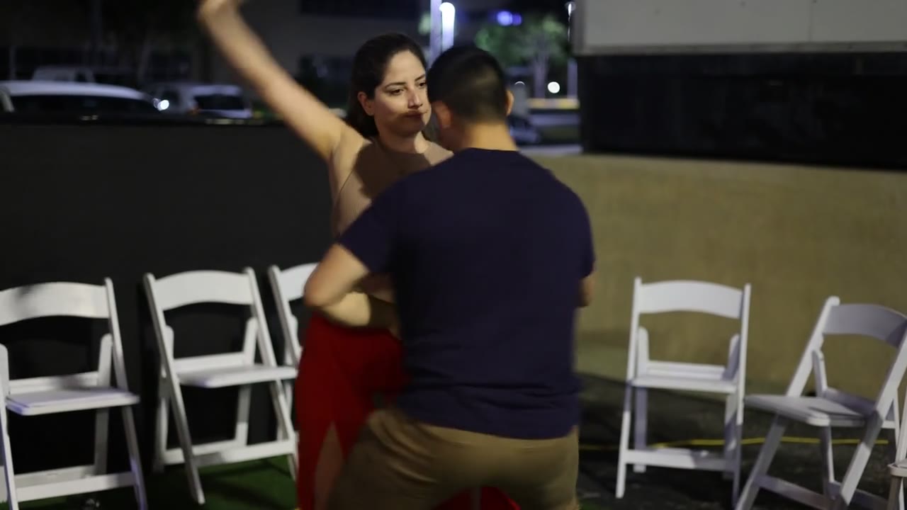 Partners dancing salsa beside the outdoor seating